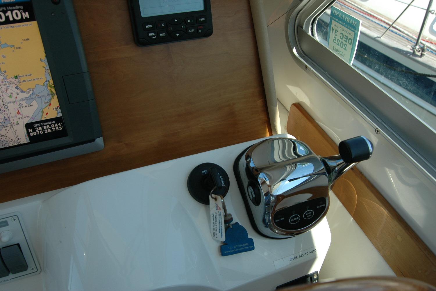 Control panel of a 2014 Back Cove 37 boat with navigation equipment and throttle.