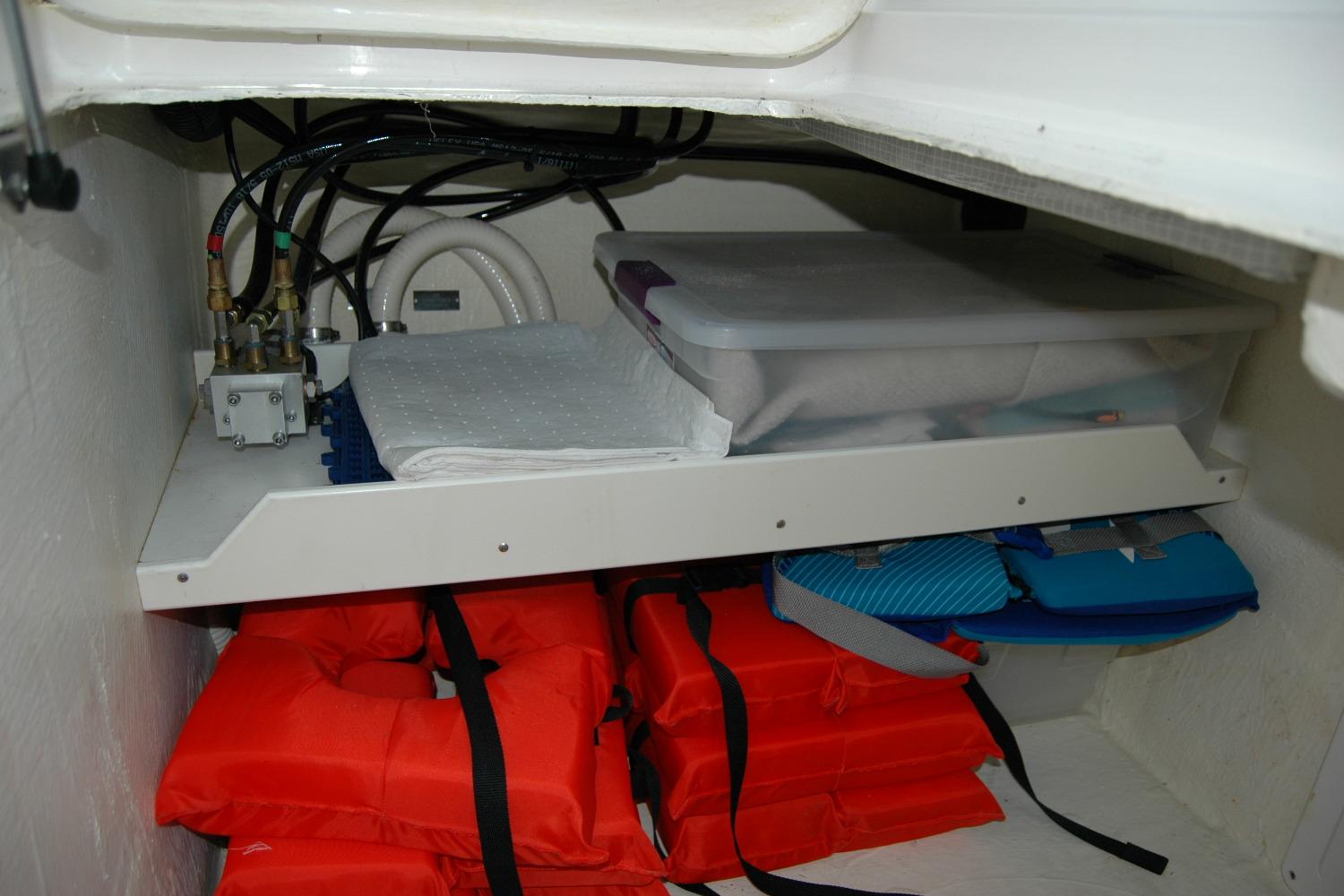Storage compartment in a 2014 Back Cove 37 boat with life jackets and supplies.