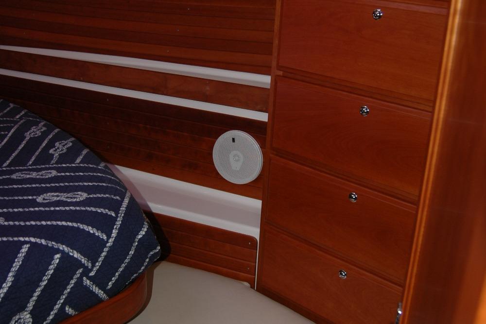 Interior of 2014 Back Cove 37 boat with wooden drawers and nautical-themed bedding.