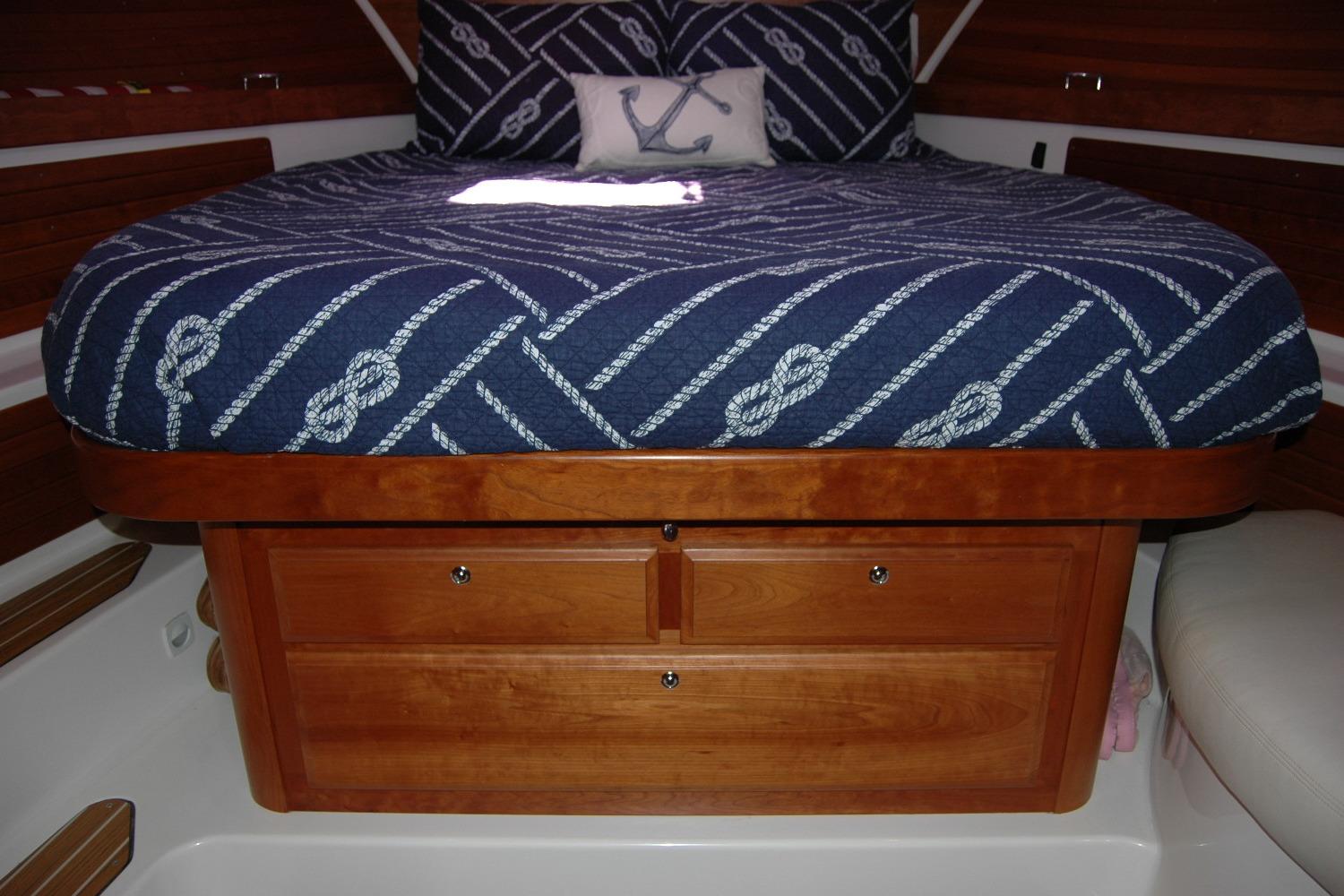 2014 Back Cove 37 cabin interior with nautical bedding and wooden storage drawers.
