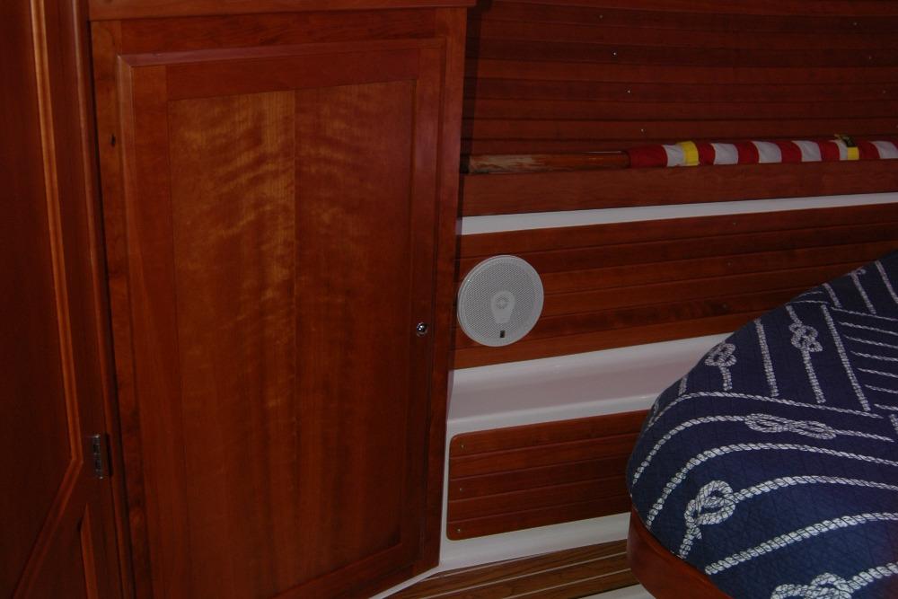 Interior of 2014 Back Cove 37 boat with wooden paneling and nautical-themed bedding.