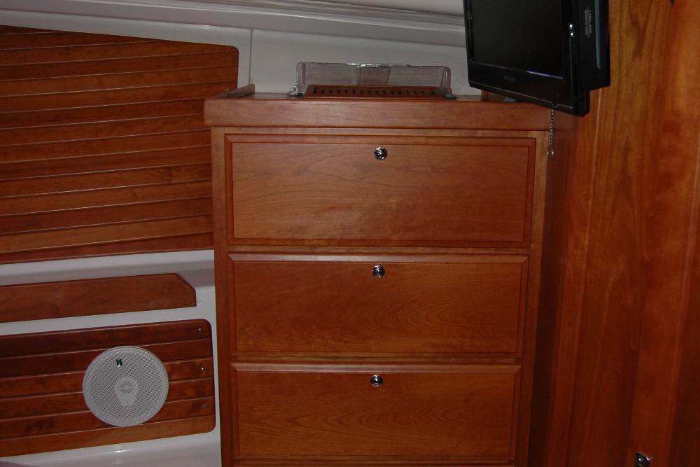Wooden cabinetry and TV inside 2014 Back Cove 37 boat interior.