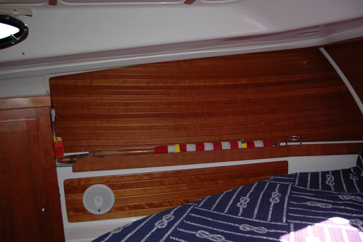 Interior of 2014 Back Cove 37 boat with wooden paneling and nautical-themed bedding.