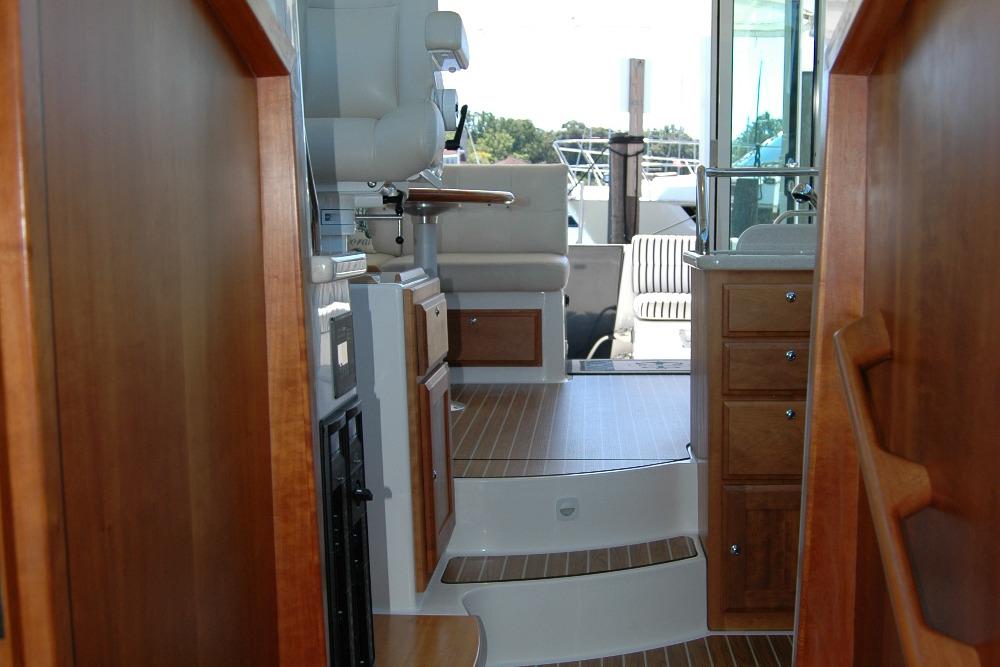 Interior view of 2014 Back Cove 37 yacht with wooden cabinetry and seating area.