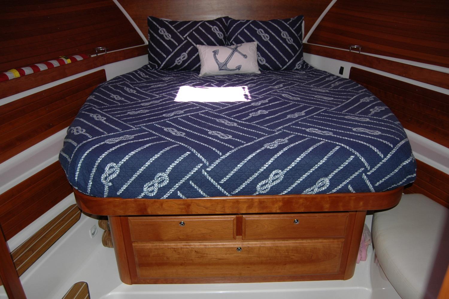 Cozy cabin interior of 2014 Back Cove 37 with nautical-themed bedding.