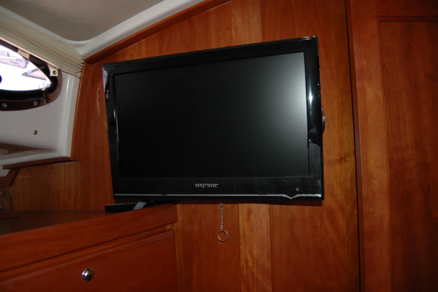 Flat-screen TV mounted on wooden interior of 2014 Back Cove 37 boat.