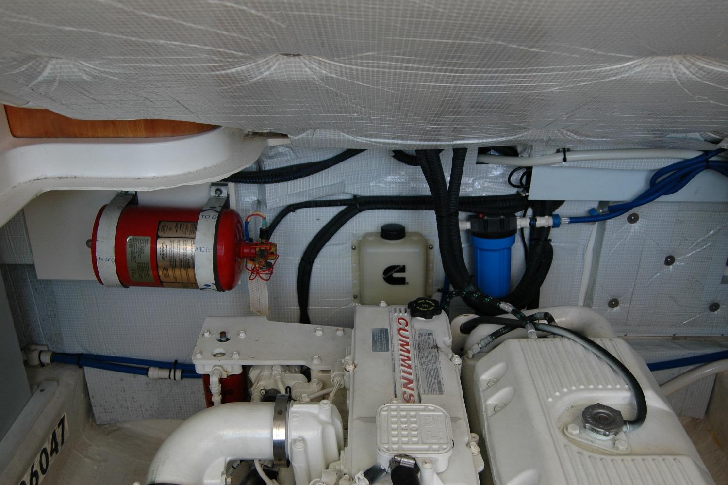 Engine room of 2014 Back Cove 37 boat with Cummins engine and fire extinguisher.
