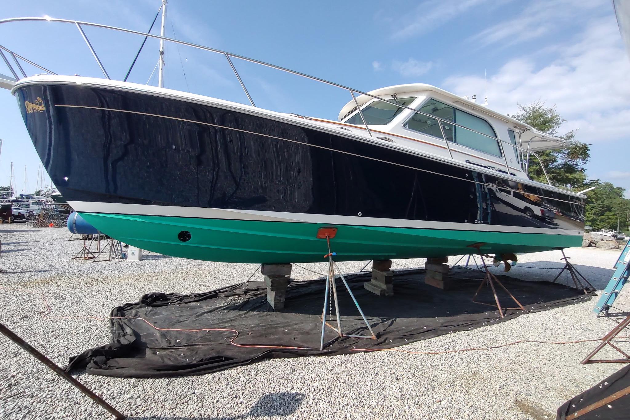 2014 Back Cove 37 boat on stands, blue hull, green bottom, outdoor setting.