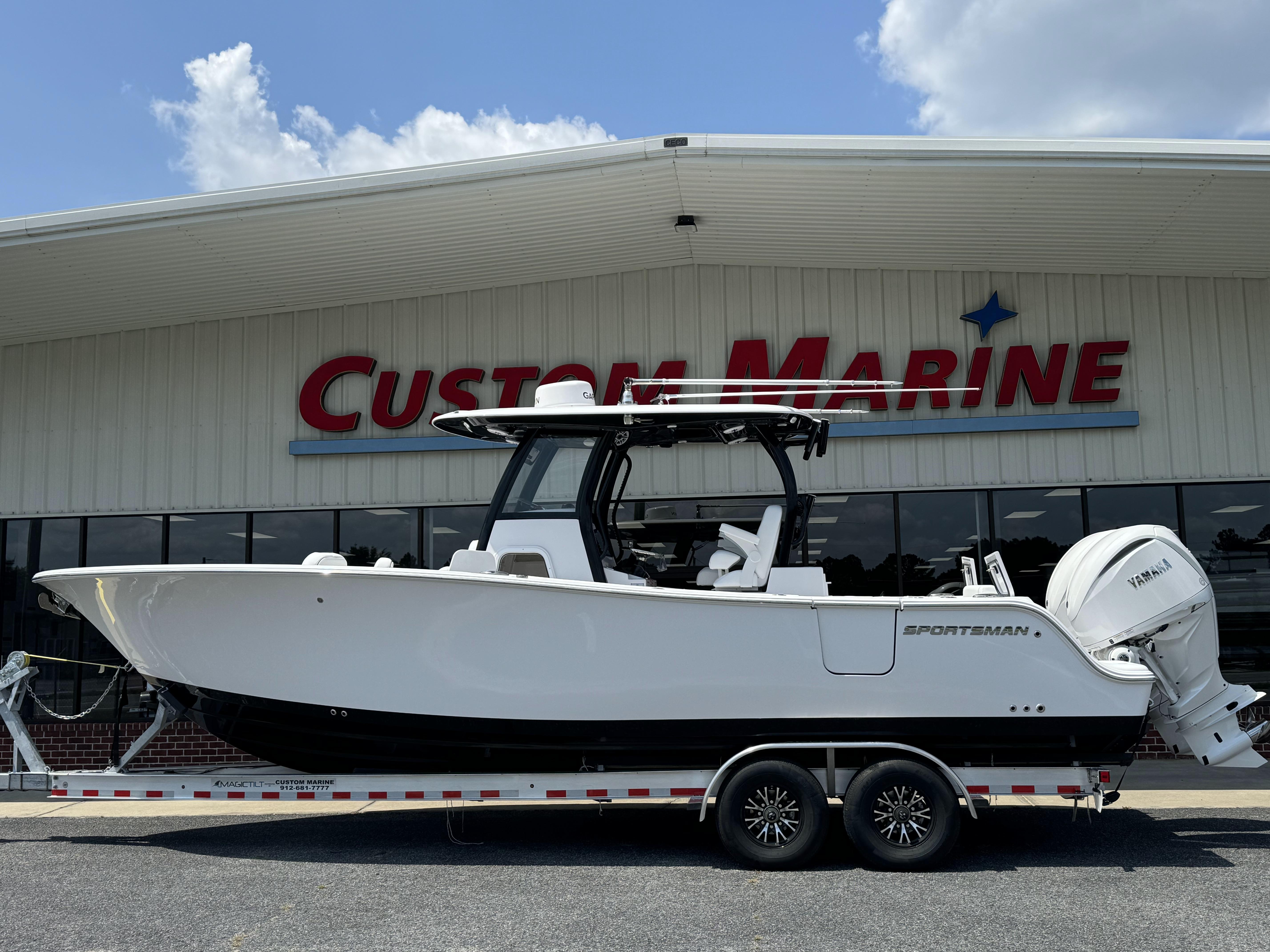 2025 Sportsman Open 282 Center Console boat on trailer at Custom Marine dealership.