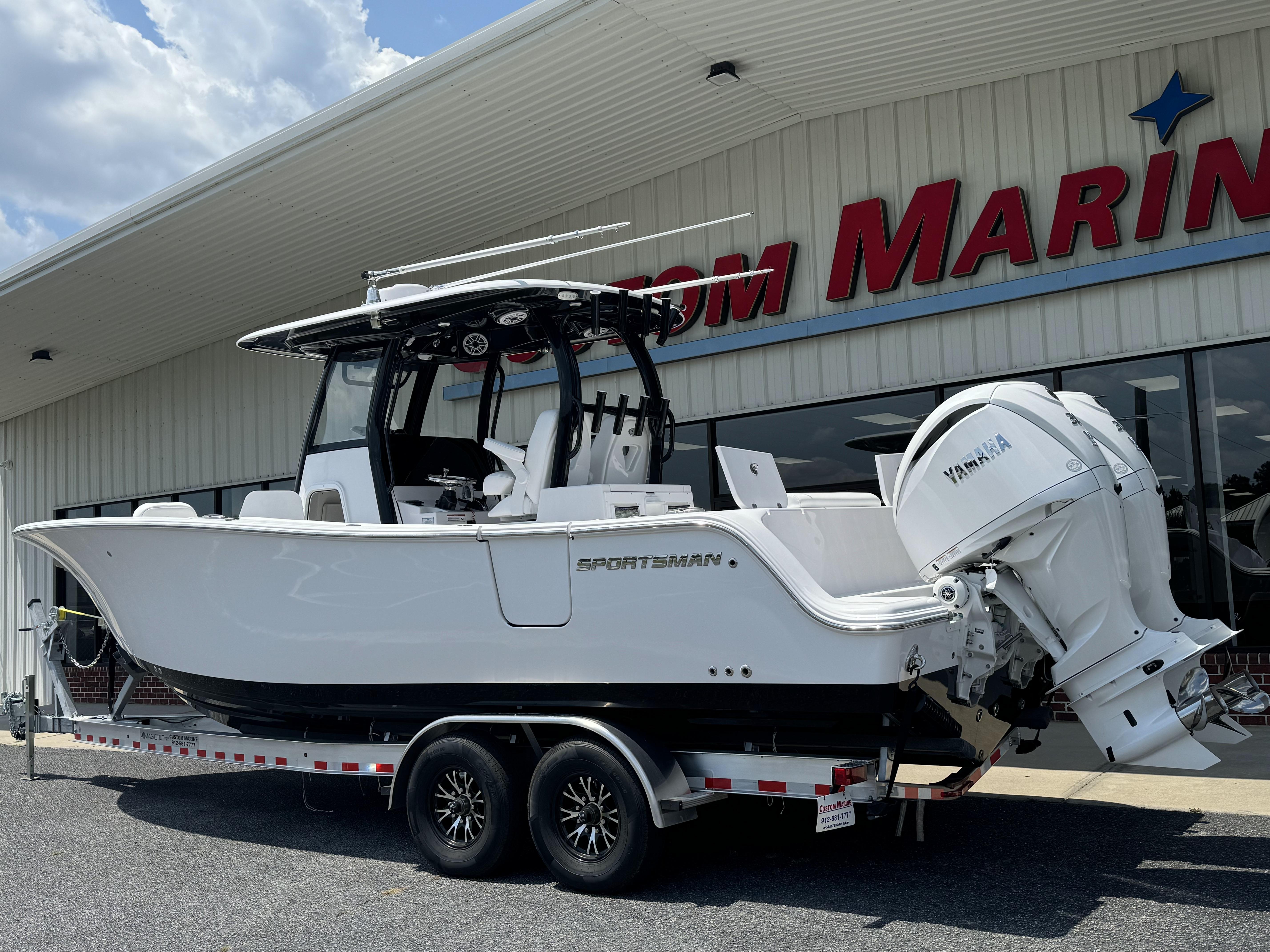 2025 Sportsman Open 282 Center Console boat on trailer outside marine dealership.
