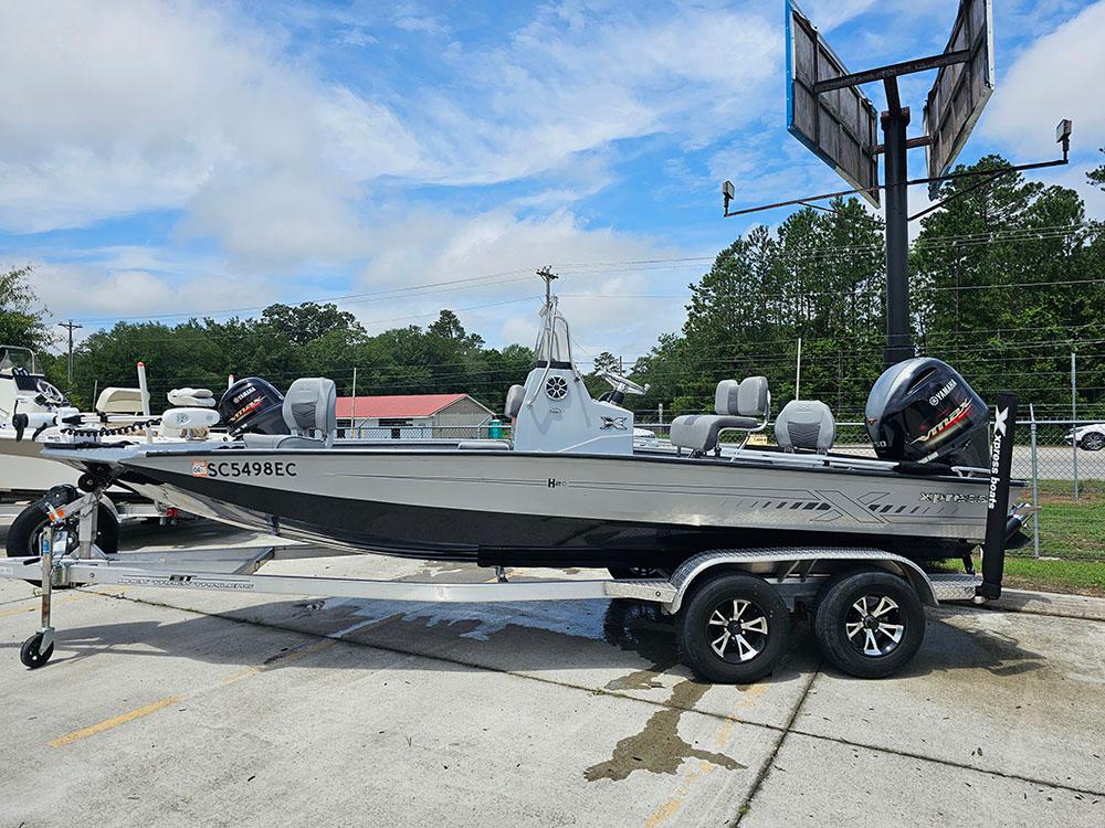 2023 Xpress H20B boat on trailer, parked outdoors under cloudy sky.