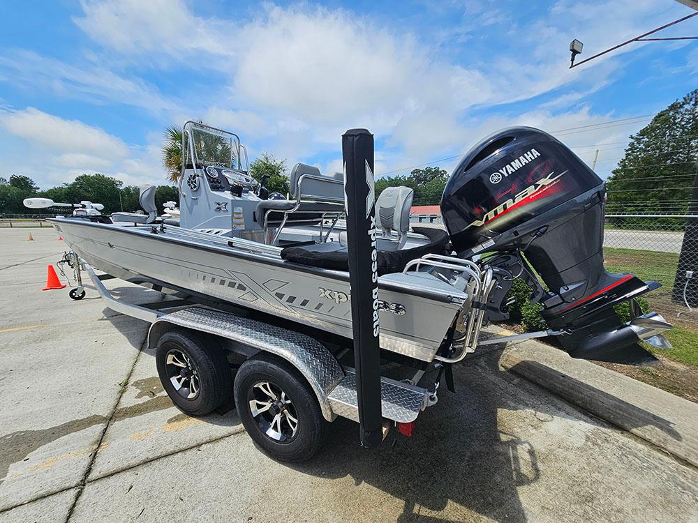 2023 Xpress H20B boat with Yamaha outboard motor on a trailer, parked outdoors.