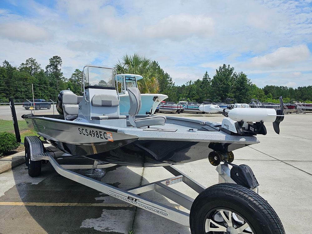 2023 Xpress H20B boat on trailer in outdoor setting, surrounded by trees and other boats.