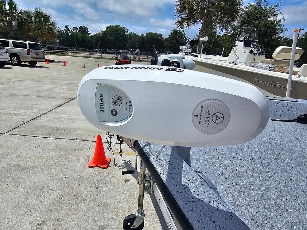 2023 Xpress H20B boat with Minn Kota Riptide trolling motor in a sunny parking lot.