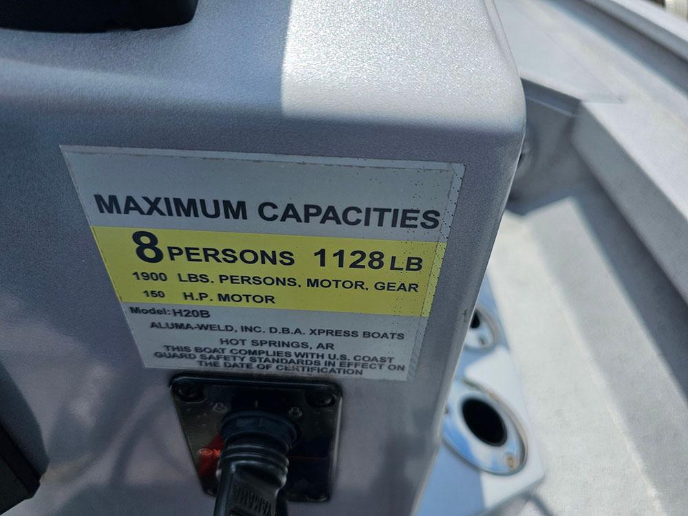 2023 Xpress H20B boat capacity label: 8 persons, 1128 lbs, 150 HP motor.