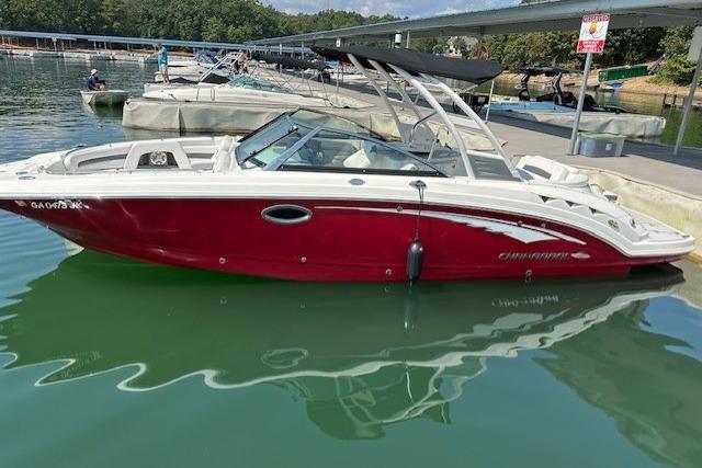 2016 Chaparral 264 Sunesta boat docked on calm water, featuring a sleek red and white design.