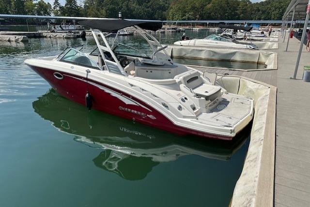 2016 Chaparral 264 Sunesta boat docked in a marina, featuring a sleek red and white design.