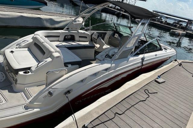2016 Chaparral 264 Sunesta boat docked at marina, featuring sleek design and spacious seating.