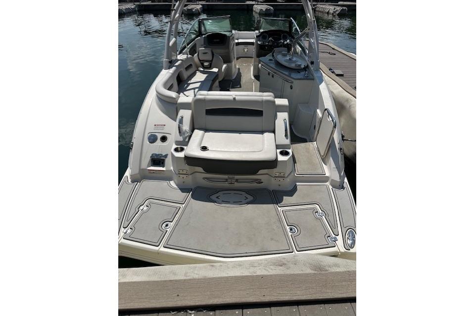 2016 Chaparral 264 Sunesta boat interior with seating and helm, docked on water.