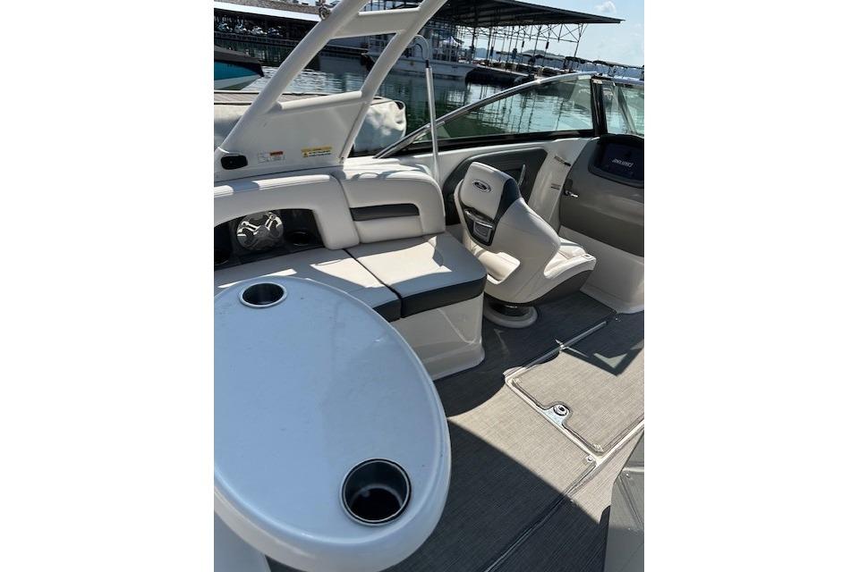 2016 Chaparral 264 Sunesta boat interior with seating and table, docked at marina.