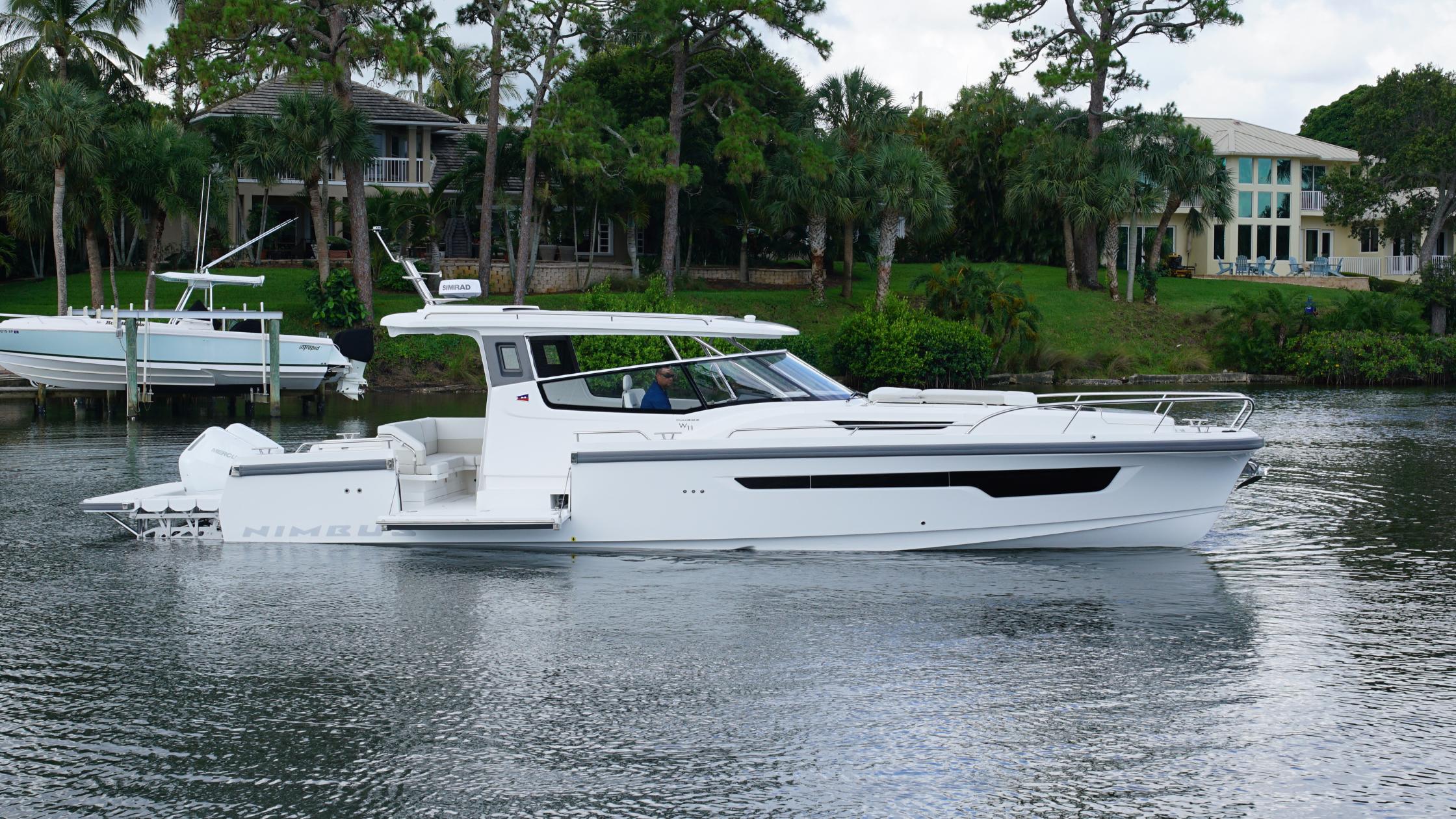 Nimbus-Weekender 11 #60 2025-In-Stock 2025 Nimbus W11 #60 FL-US-2025 Nimbus Weekender 11 #60 boat on a serene waterway, surrounded by lush greenery.-9829239 | Thumbnail