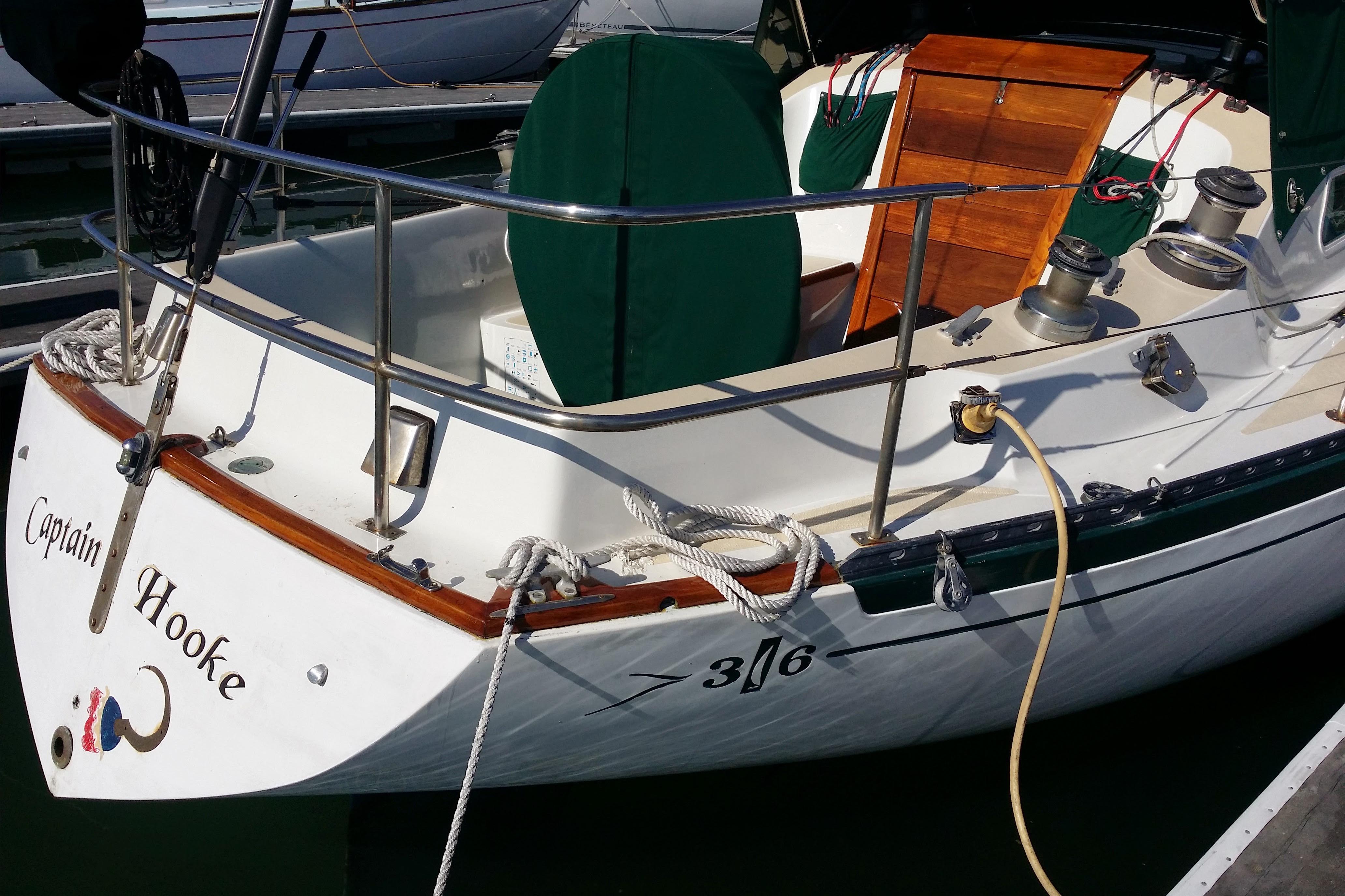 1978 Islander 36 sailboat "Captain Hooke" docked, featuring wooden accents and nautical equipment.