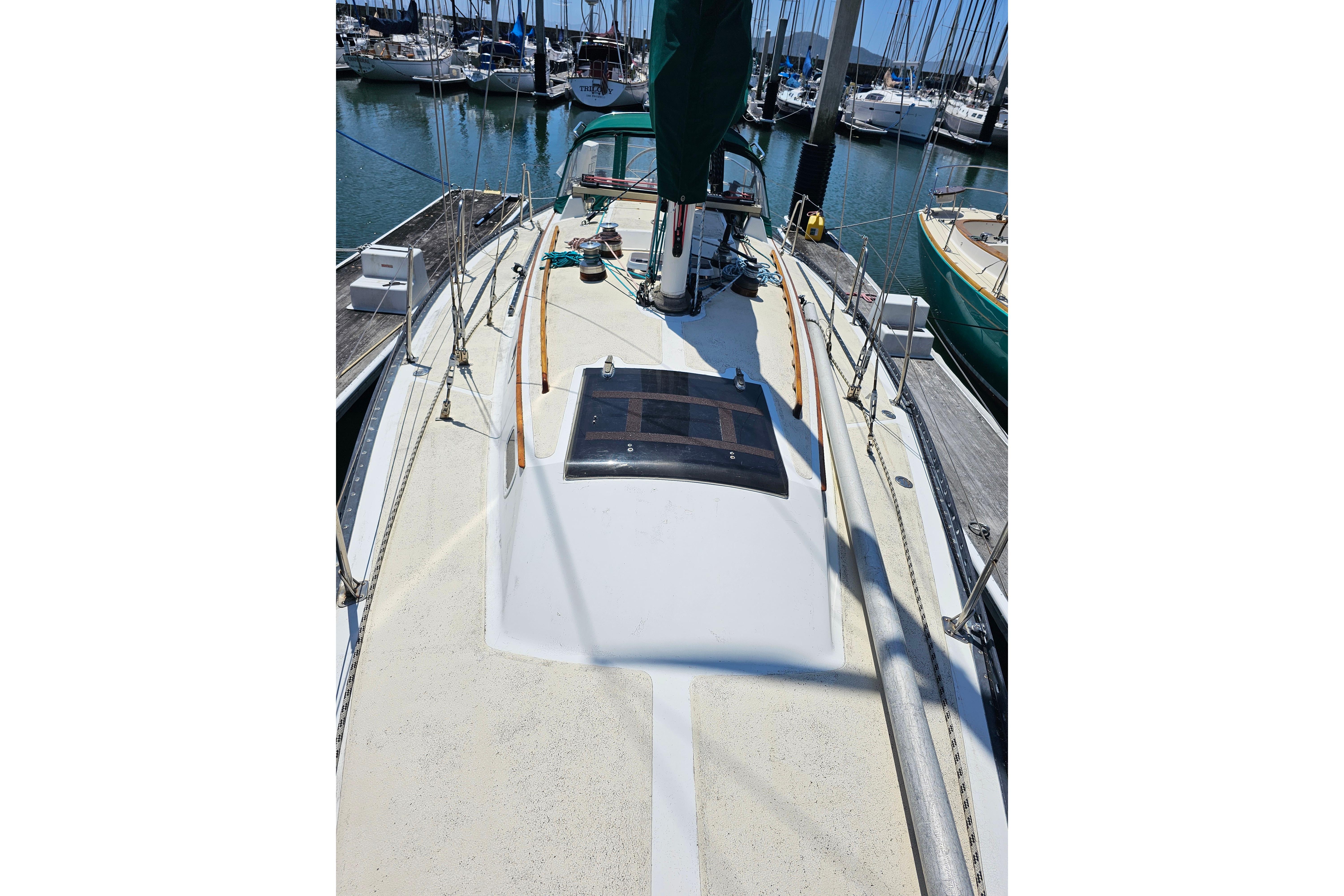 1978 Islander 36 sailboat deck view in marina with surrounding boats.