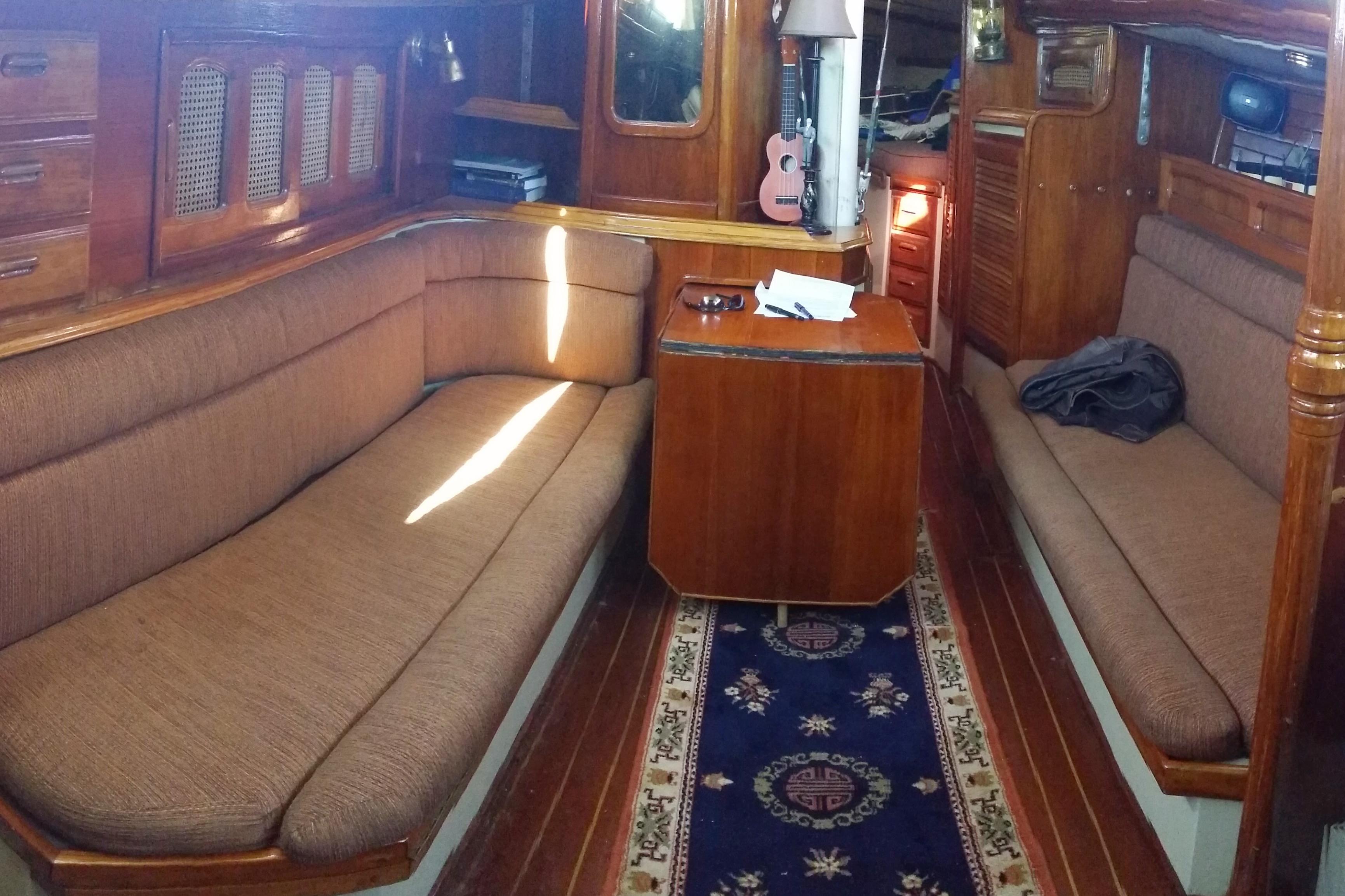 1978 Islander 36 yacht interior with wooden furnishings and cozy seating area.