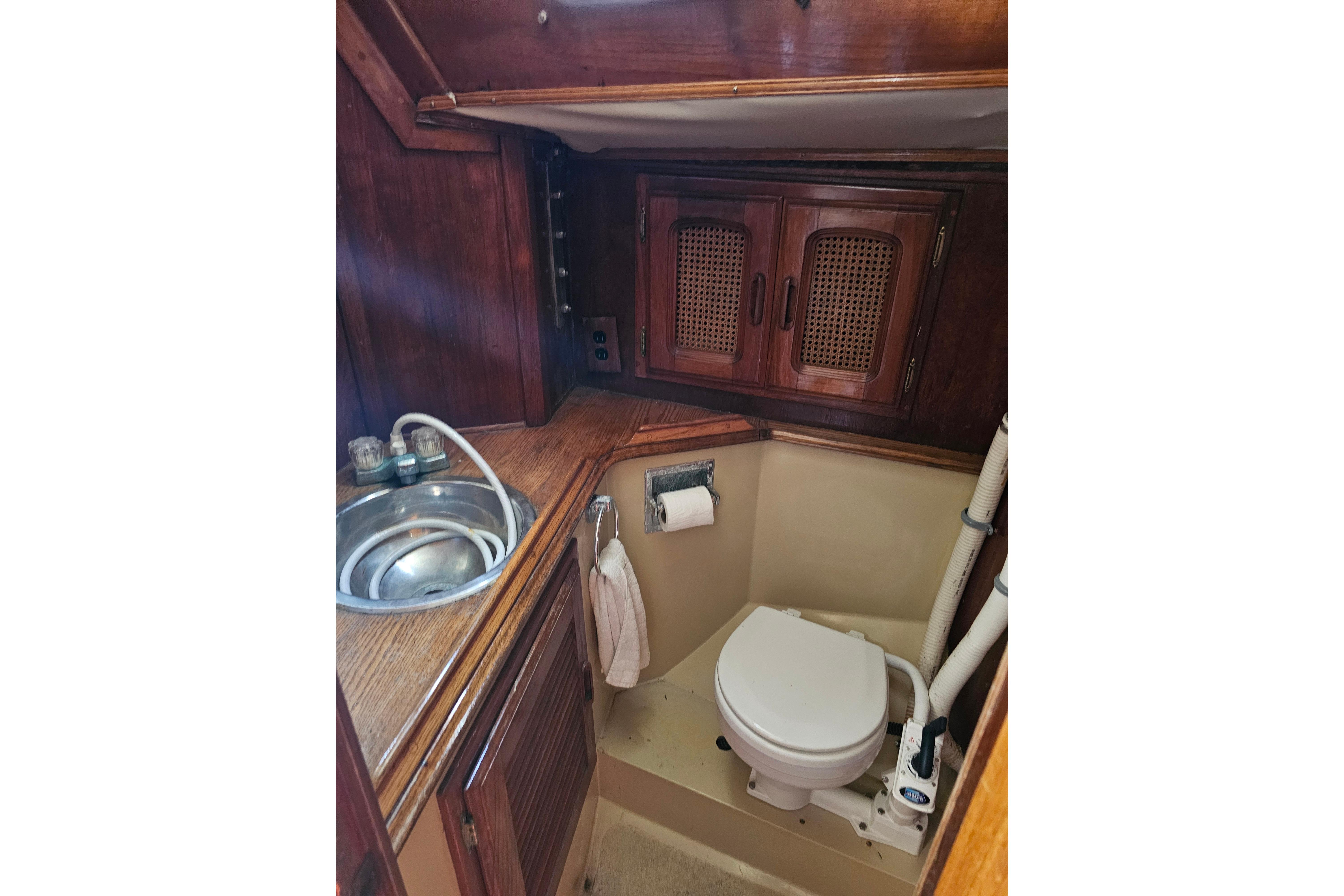 1978 Islander 36 yacht bathroom with wooden cabinets and compact sink.
