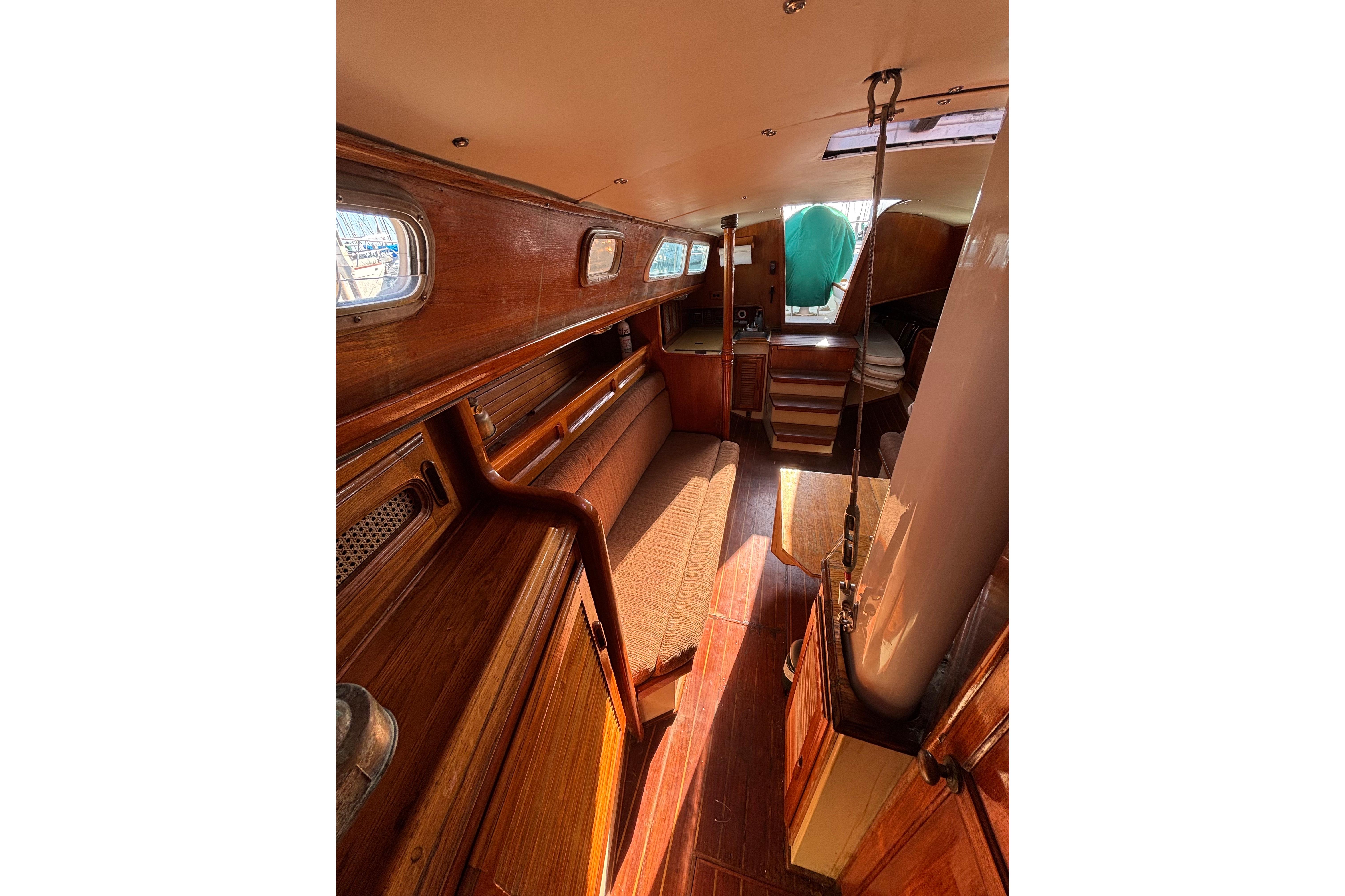 1978 Islander 36 sailboat interior with wooden finish and cozy seating area.