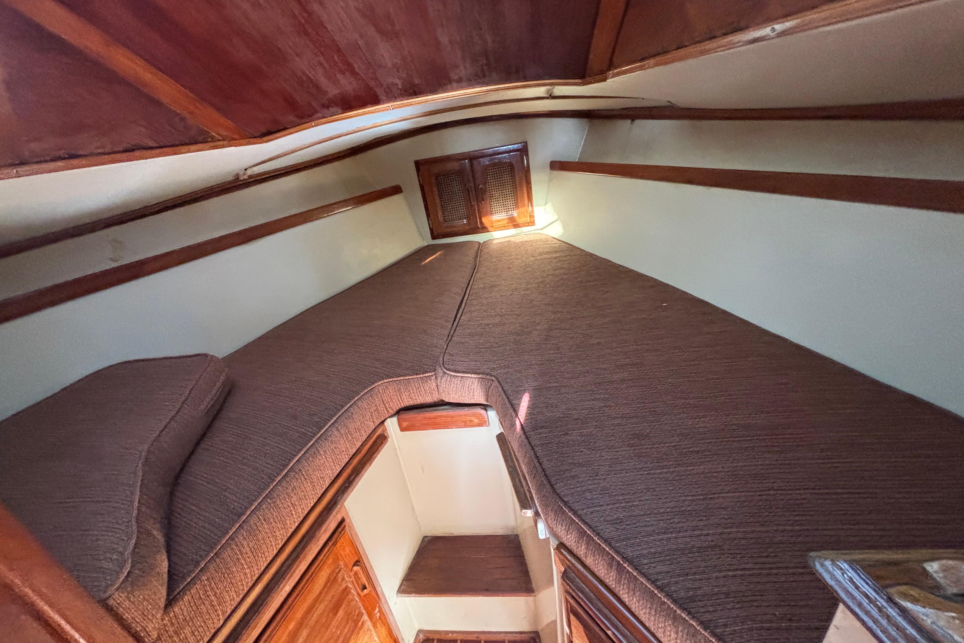 1978 Islander 36 sailboat interior cabin with cozy brown cushions and wooden accents.