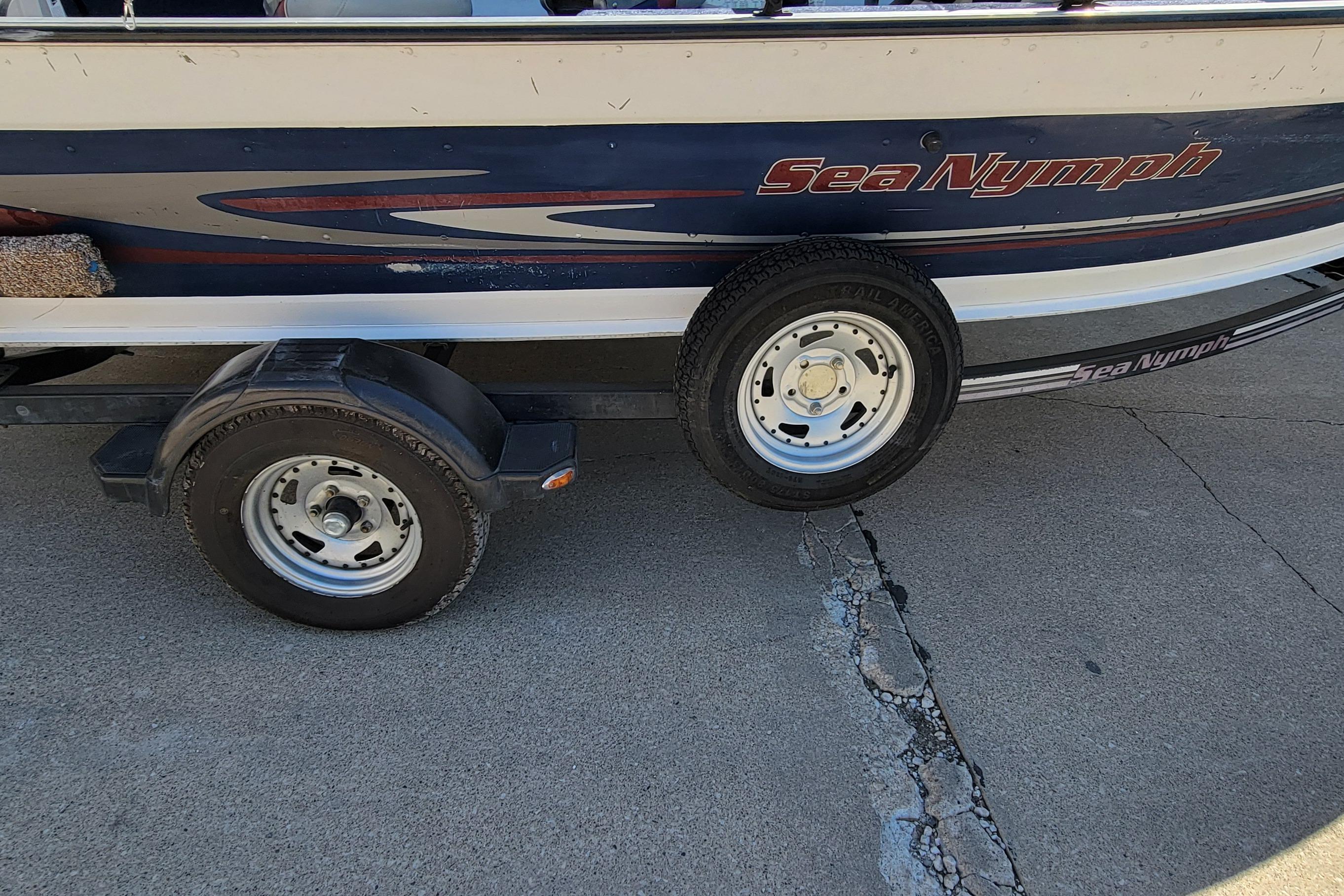 1997 Sea Nymph 168 DLX boat on trailer, side view, parked on concrete.