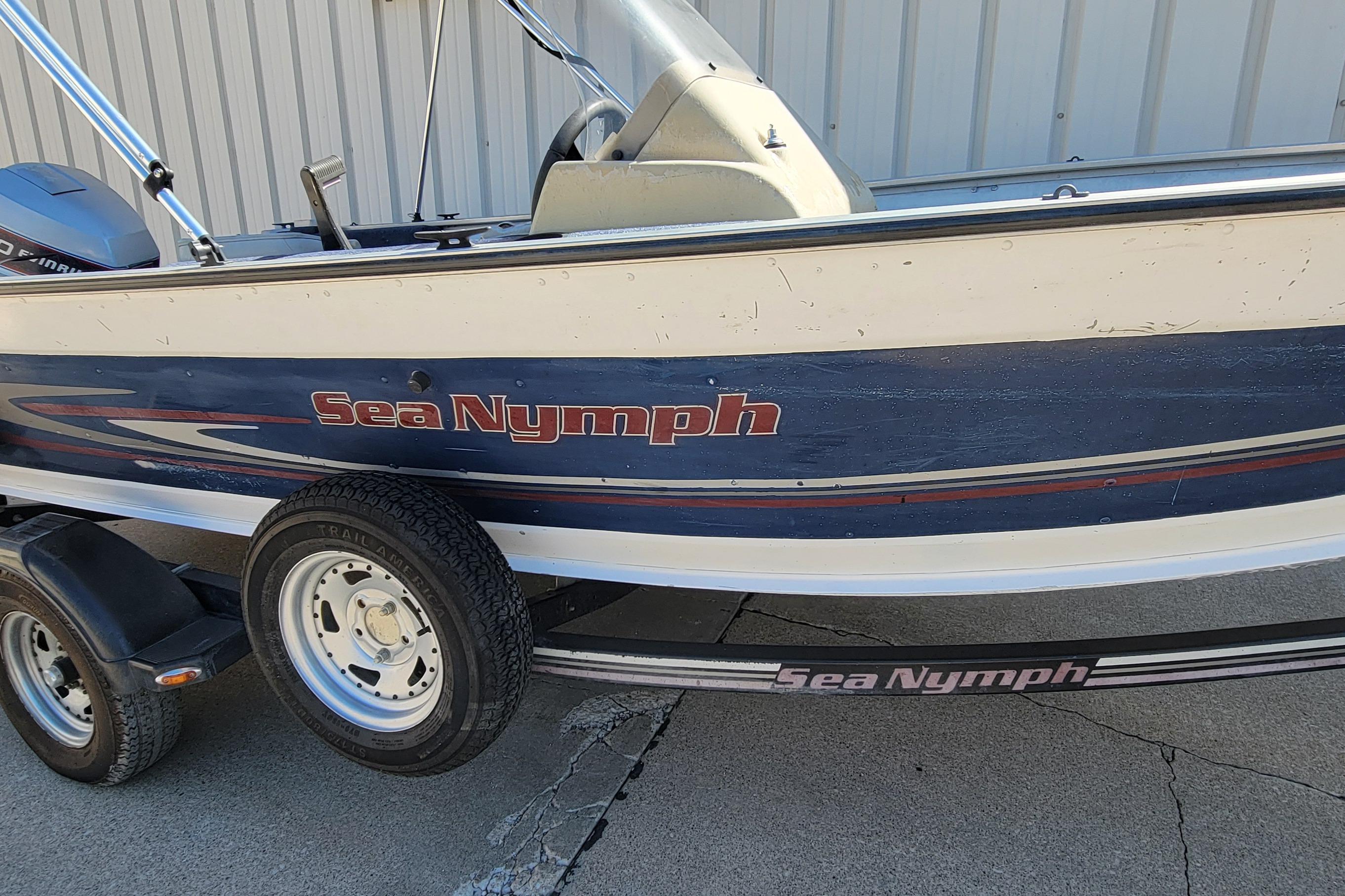 1997 Sea Nymph 168 DLX boat on trailer, blue and white design, parked outdoors.