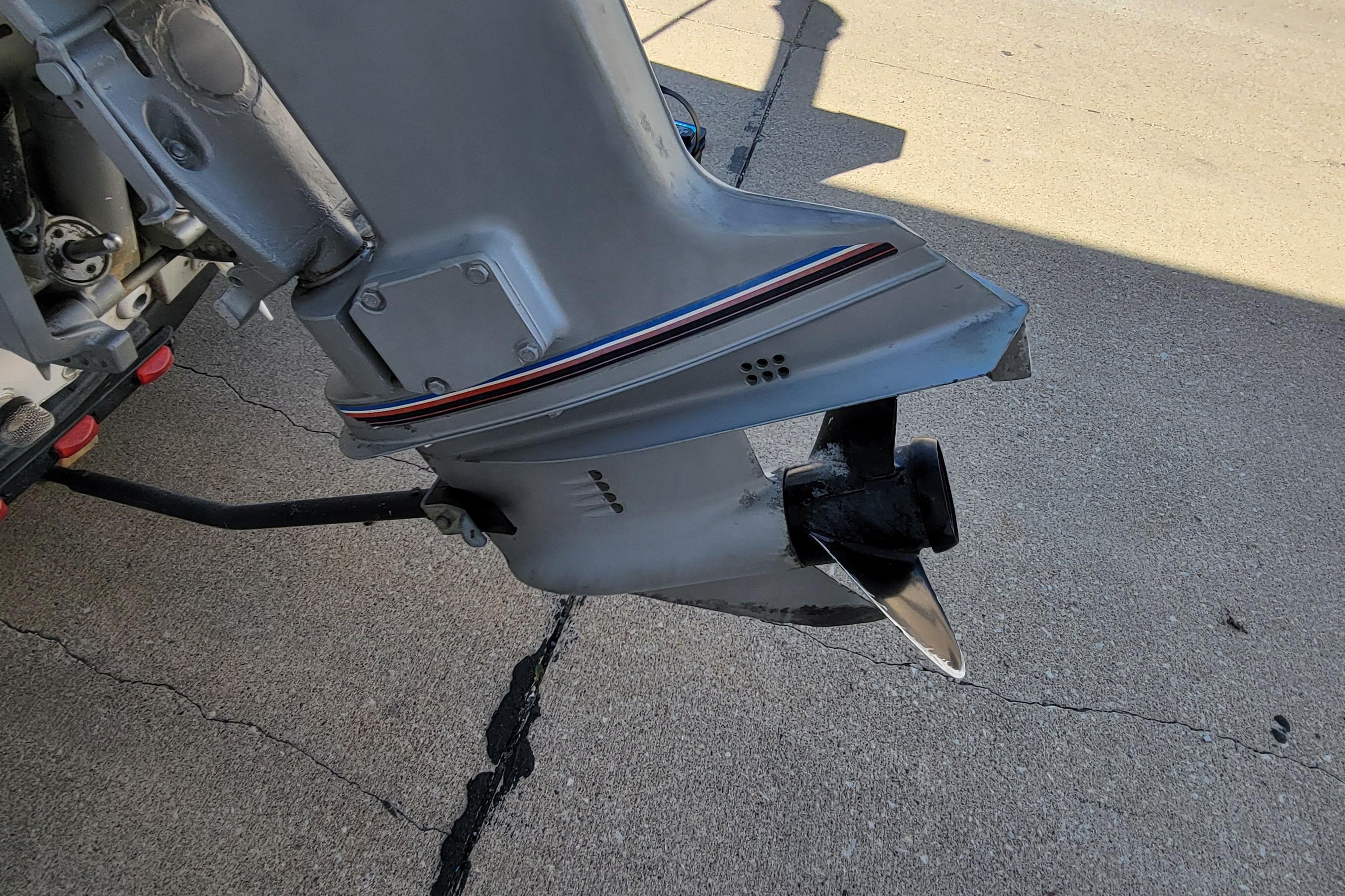 Outboard motor of a 1997 Sea Nymph 168 DLX on concrete surface.