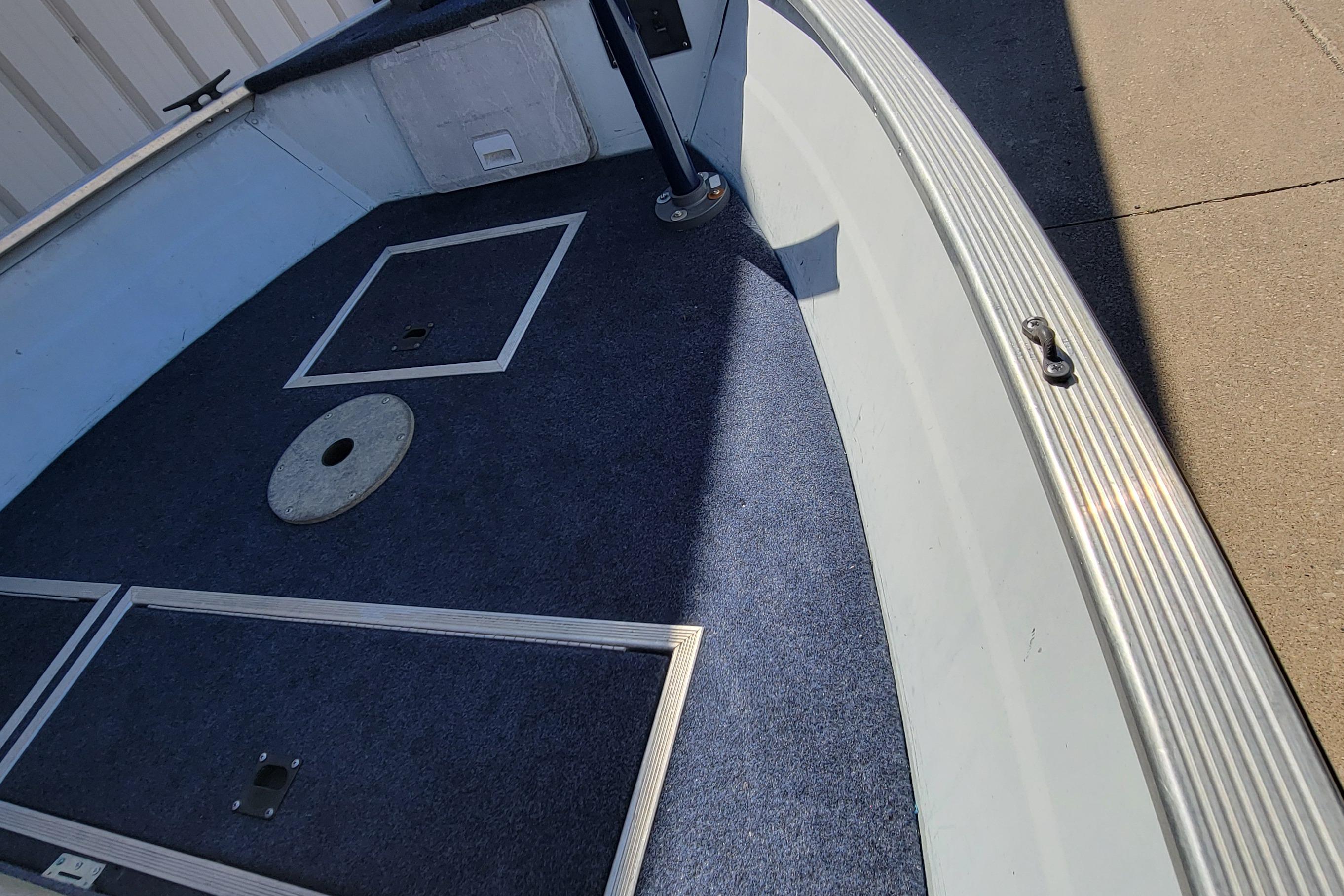 1997 Sea Nymph 168 DLX boat interior with blue carpet and storage compartments.
