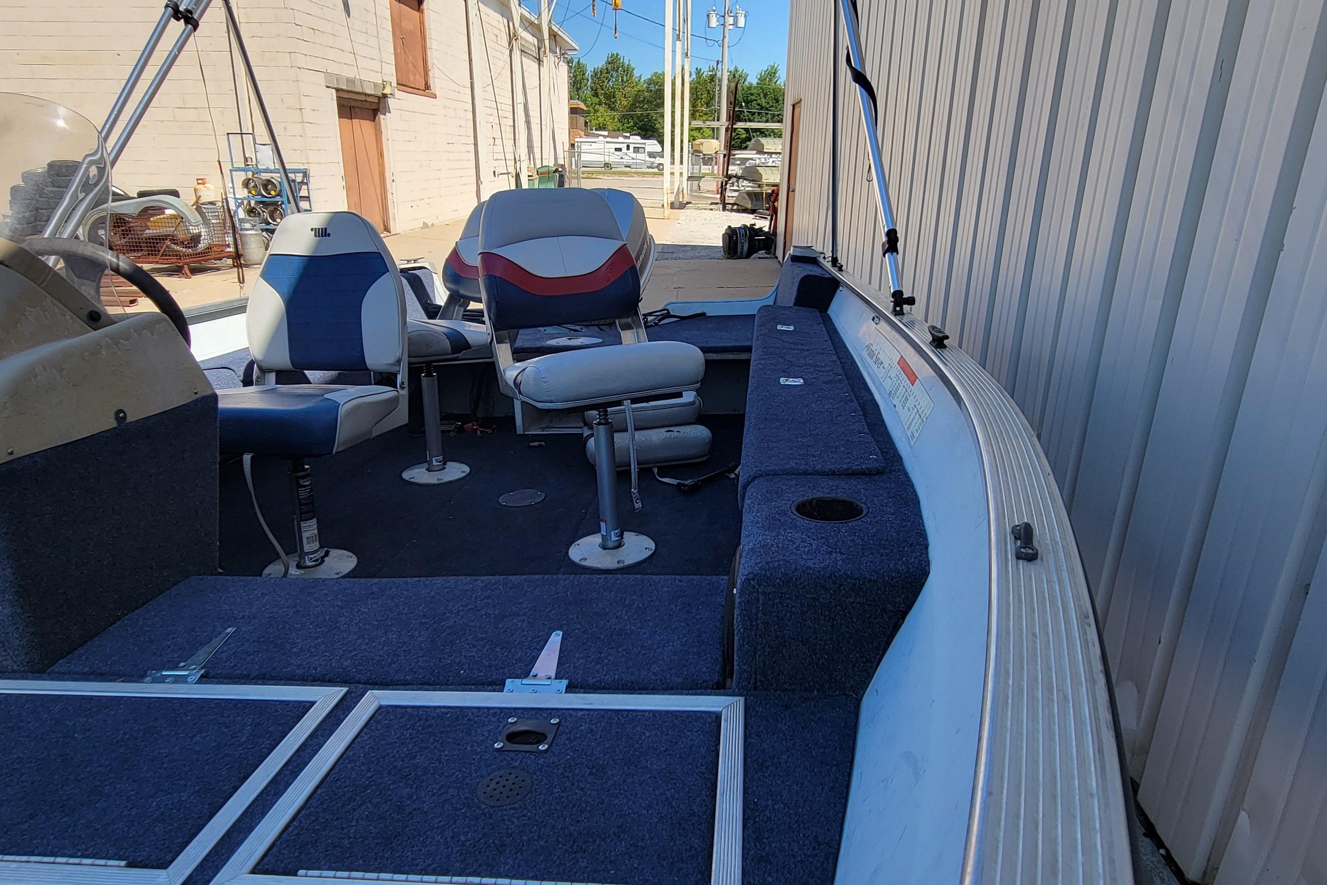 1997 Sea Nymph 168 DLX boat interior with blue seating and storage compartments.
