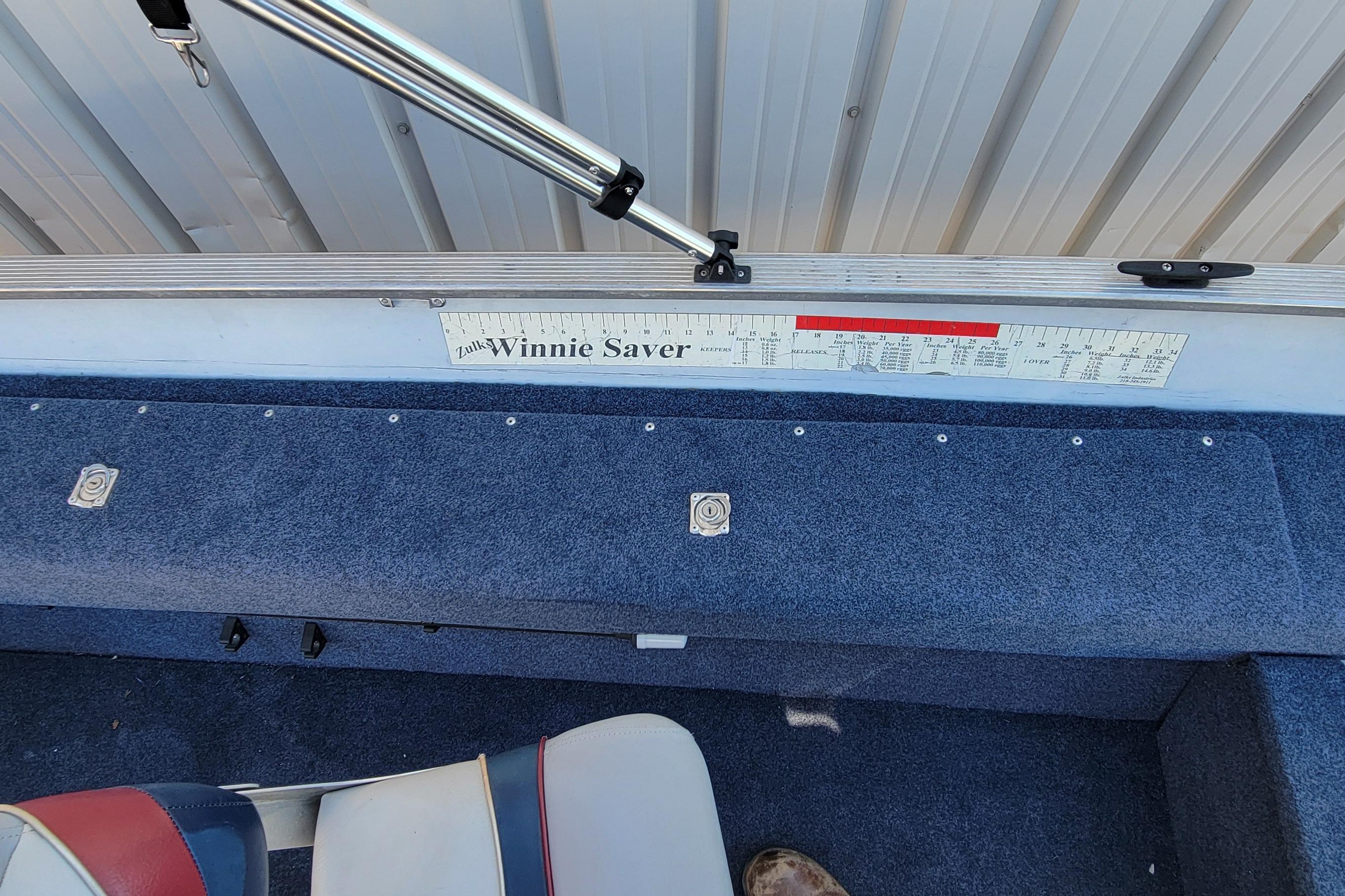 1997 Sea Nymph 168 DLX boat interior with measuring ruler and blue carpet.