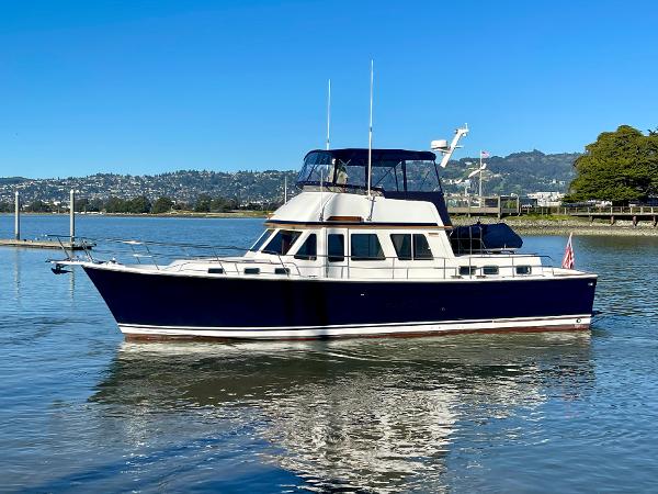 1997 Sabre Cockpit Motor Yacht on calm water, clear sky background.