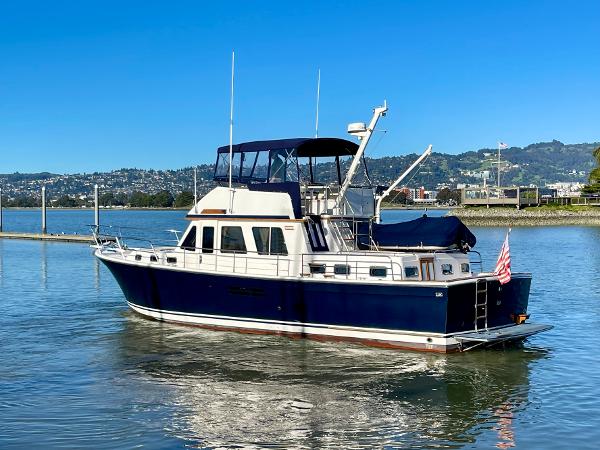 1997 Sabre Cockpit Motor Yacht on calm water with scenic background.