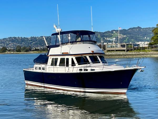 1997 Sabre Cockpit Motor Yacht on calm water with scenic background.