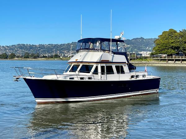 1997 Sabre Cockpit Motor Yacht on calm water with scenic background.