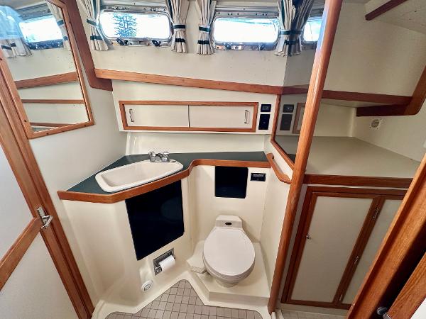 1997 Sabre Cockpit Motor Yacht bathroom with sink, toilet, and storage cabinets.