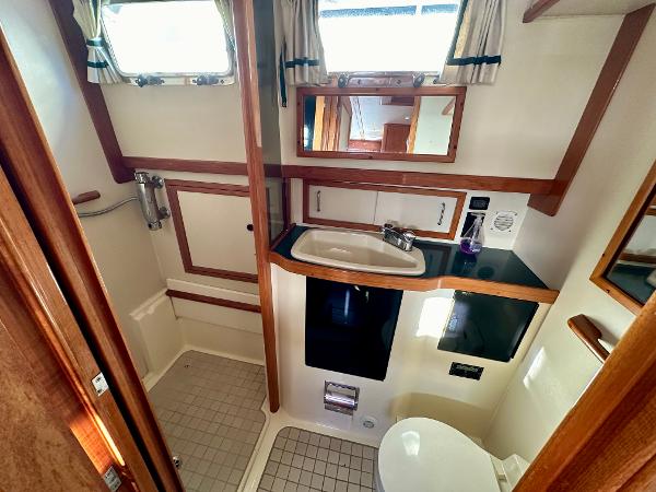 1997 Sabre Cockpit Motor Yacht bathroom with sink, mirror, and shower area.