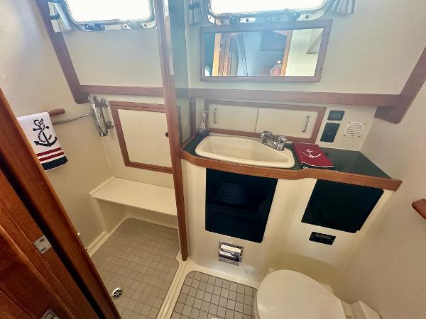 1997 Sabre Cockpit Motor Yacht bathroom with sink, toilet, and nautical-themed decor.