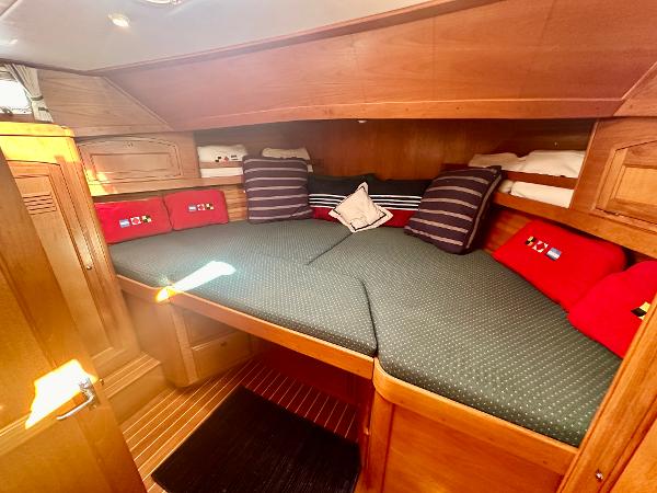 1997 Sabre Cockpit Motor Yacht cabin with cozy bedding and wooden interior.