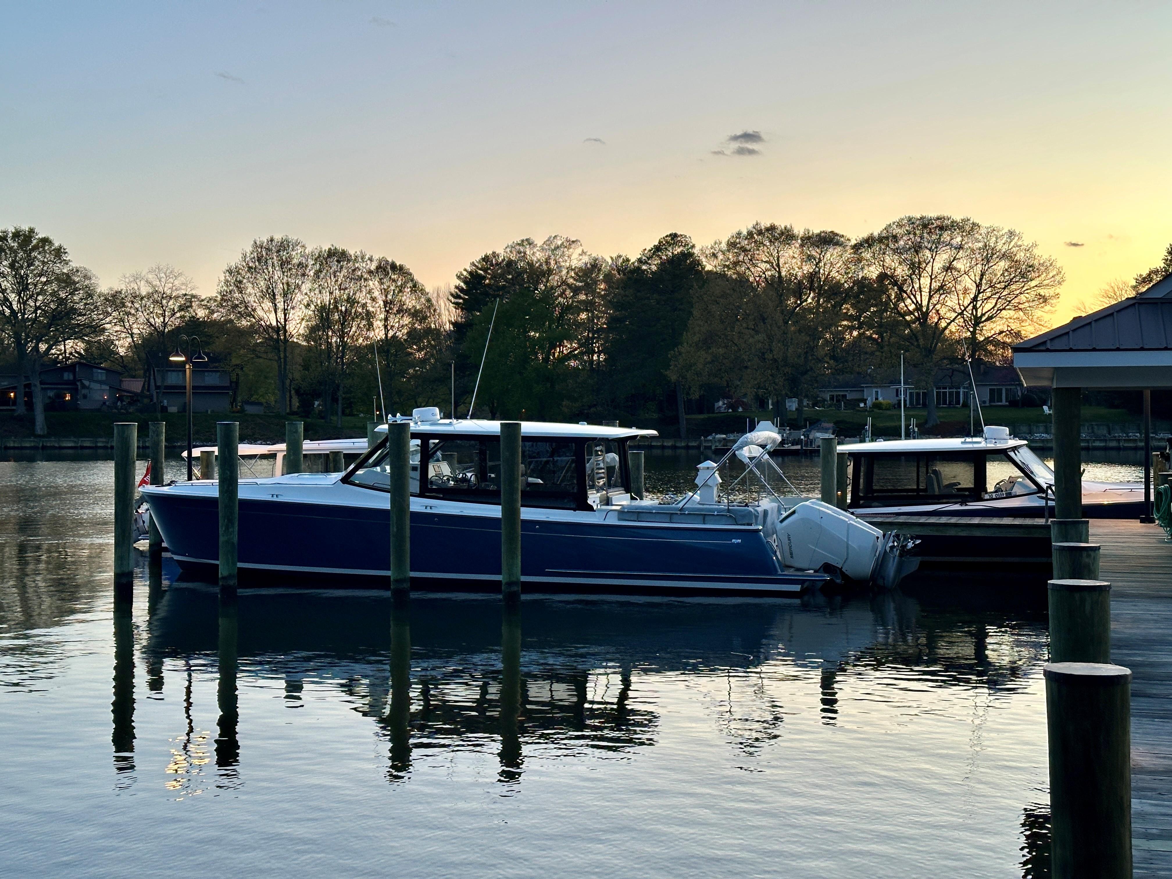 2025 MJM 4 boat docked at sunset, reflecting on calm water.