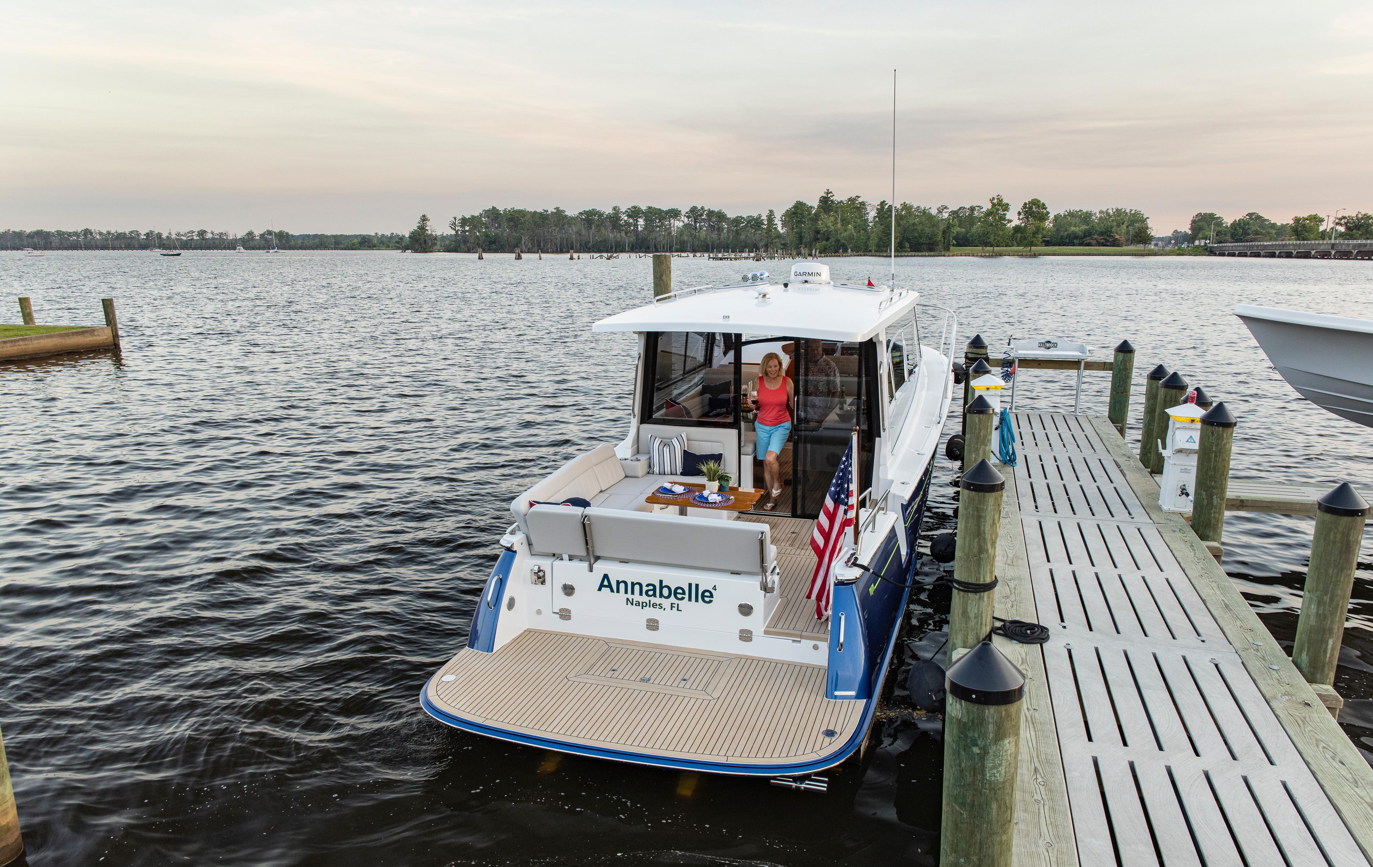 2025 MJM 42 yacht docked, featuring a person onboard, with an American flag displayed.