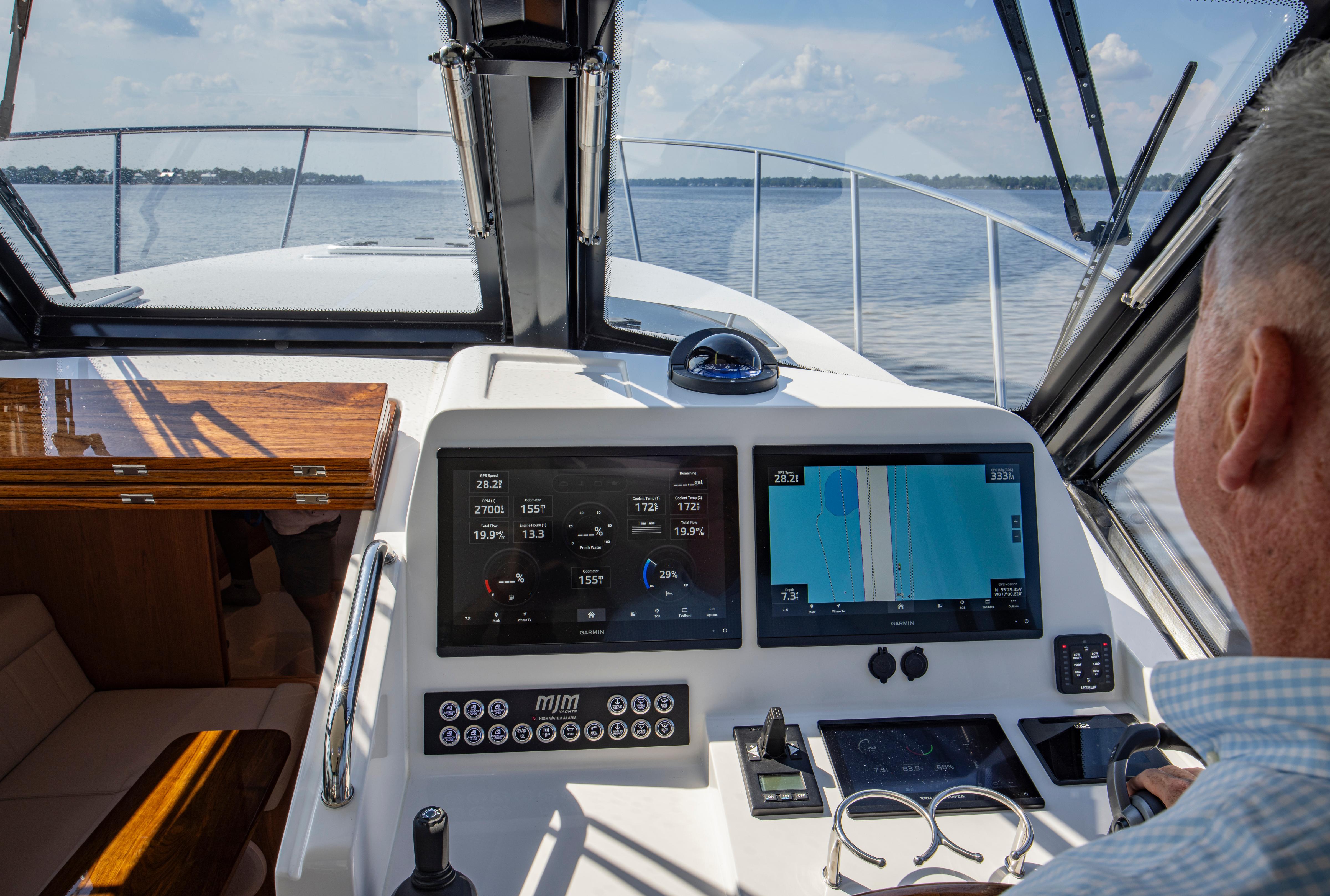 Helm of 2025 MJM 42 yacht with advanced navigation displays on open water.