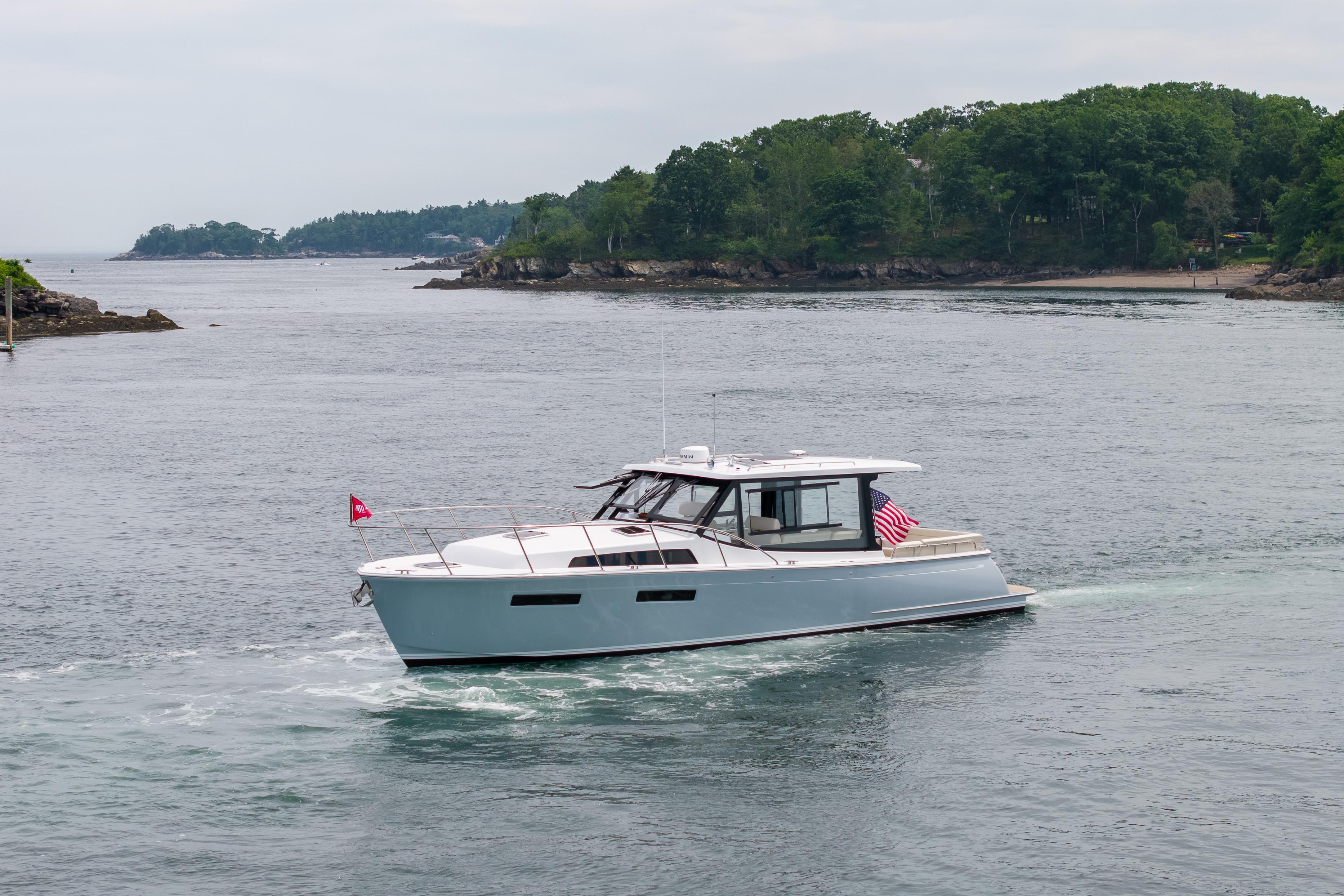 2025 MJM 42 yacht cruising on a scenic coastal waterway.
