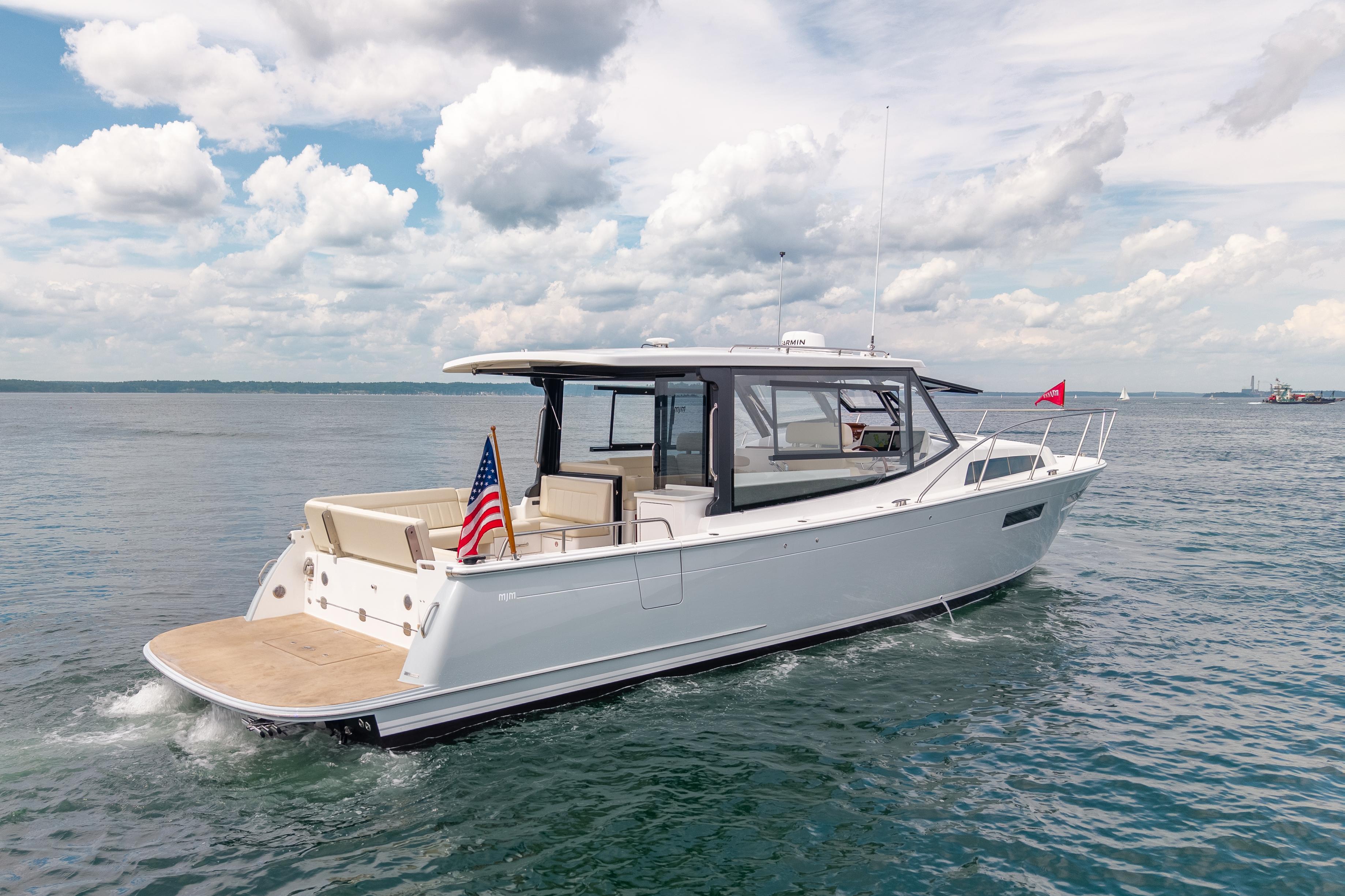 2025 MJM 42 yacht cruising on open water under a partly cloudy sky.